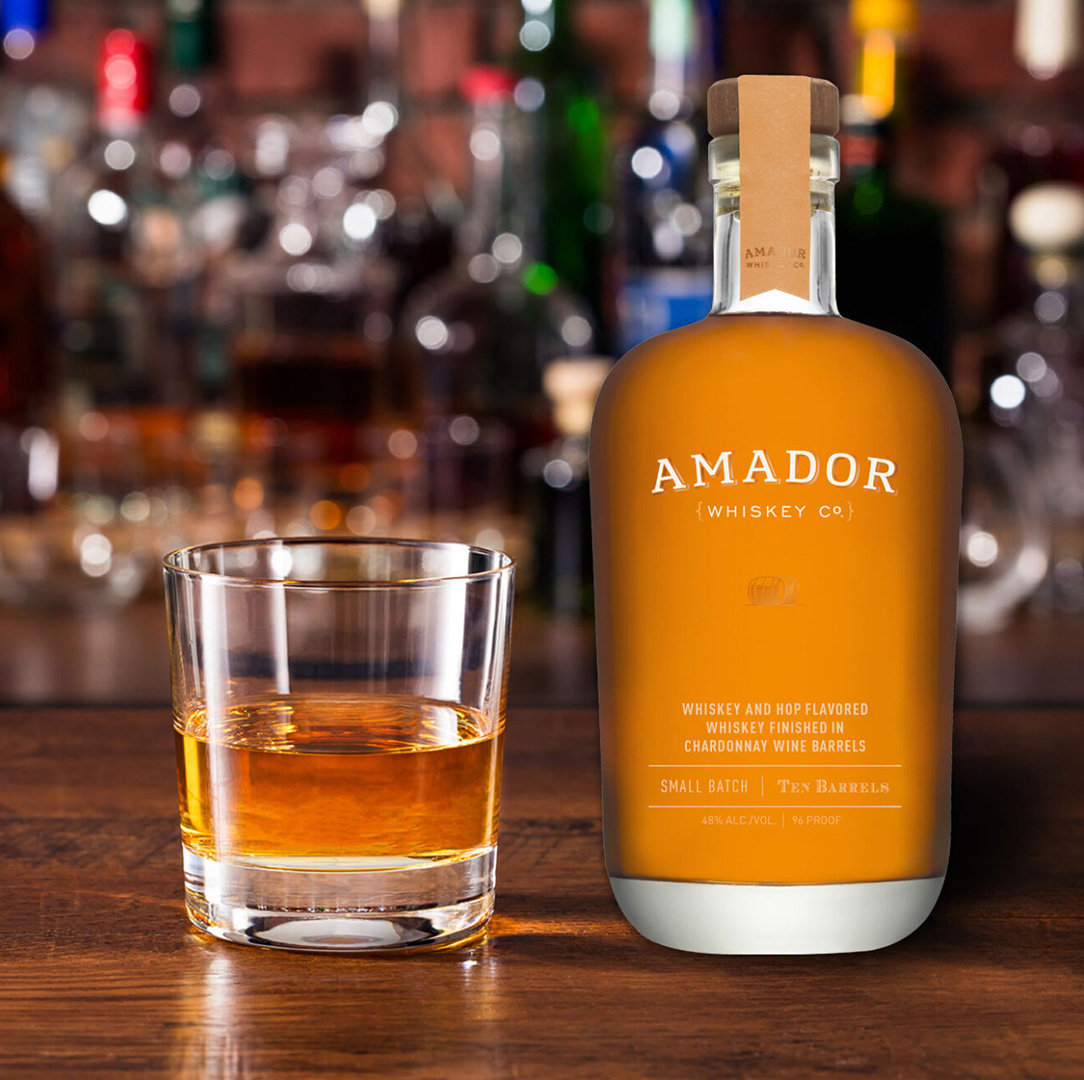 Color image of a bottle of Amador Whiskey Co whiskey with a cocktail on a bar