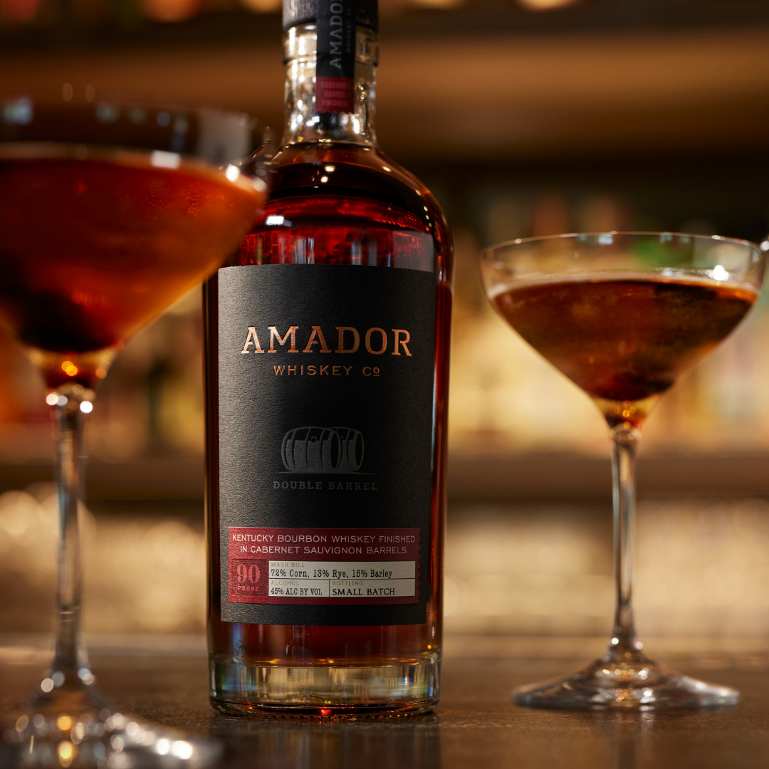 Color image of a bottle of Amador Whiskey Co whiskey with two cocktails on a bar