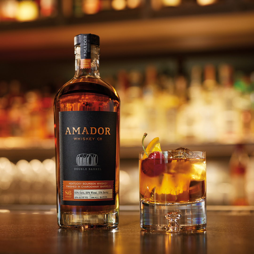 Color image of a bottle of Amador Whiskey Co whiskey with a glass of whiskey on a bar