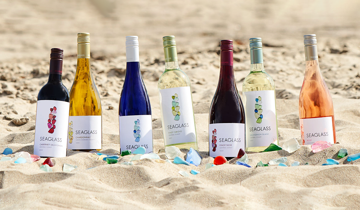 Color image of SEAGLASS Wine Co bottles in the sand on the beach